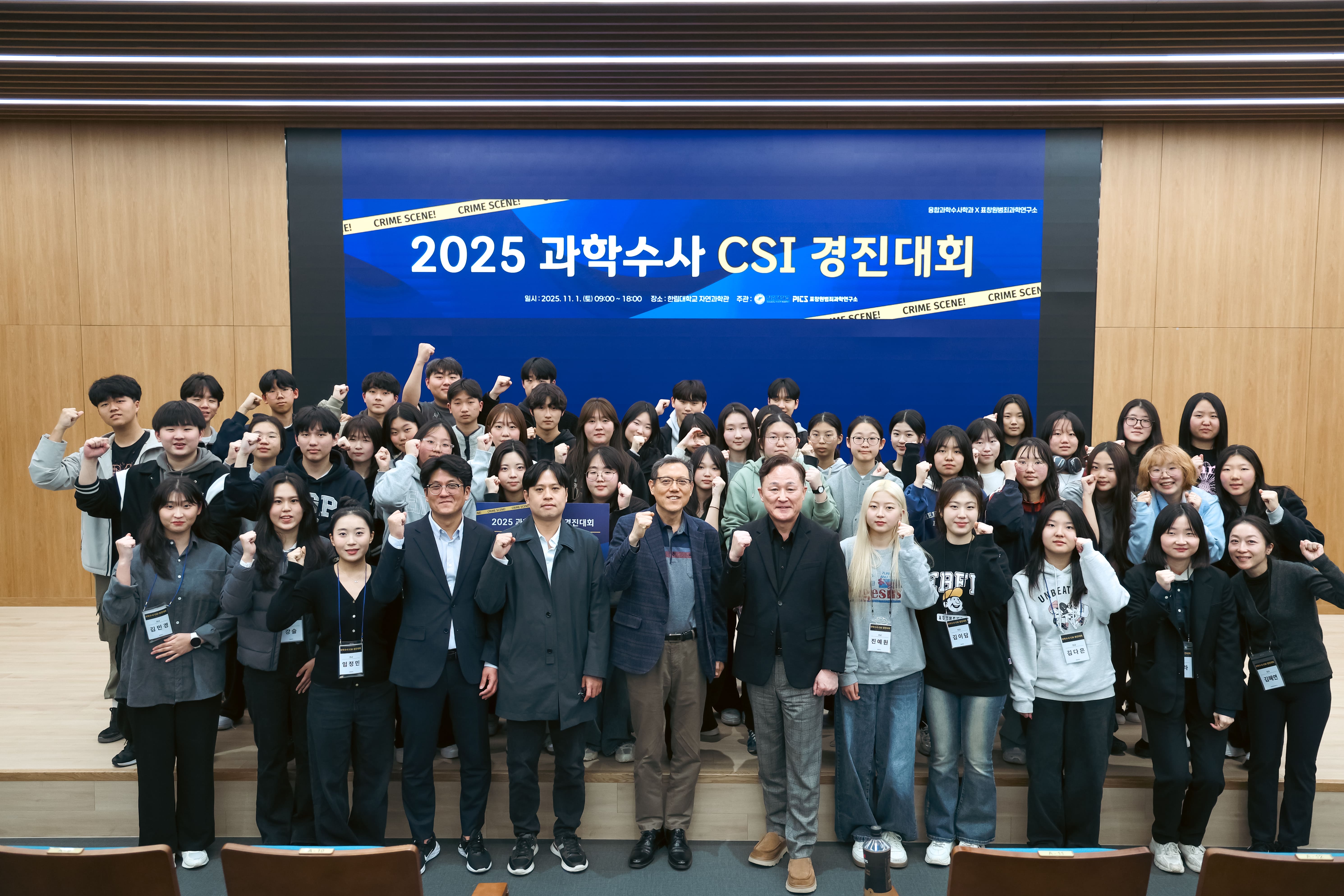 25년 11월 1일에 개최한 과학수사 경진대회 모든 참여자들이 강단에 모여 단체로 찍은 사진. 주먹을 들고 파이팅을 외치고 있다.